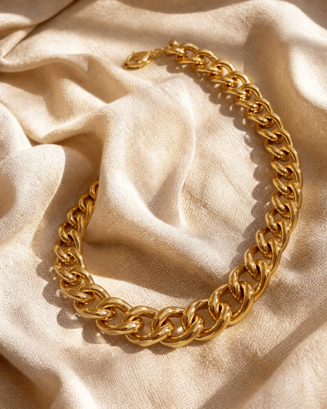 A gold-plated chunky chain necklace on neutral linen